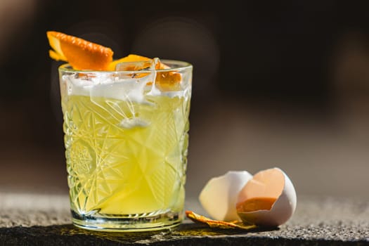 Closeup glass of whiskey sour cocktail decorated with lemon at bar background. Shallow dof