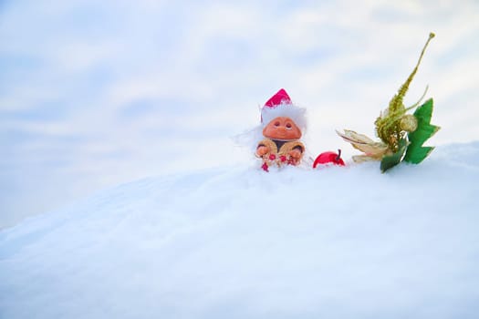 Cute little funny dwarf And a shiny twig in the snow in the landscape in winter. Wizard on a snowy background. Christmas and New Year
