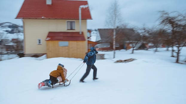 Father and kids sledding in winter. Little girl and boy enjoy a sleigh ride in the backyard. Child sledding. Outdoor fun for family. download image