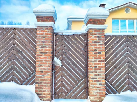 New gate, entrance to a private territory on a winter day and snow. Metallic texture and background. Fence