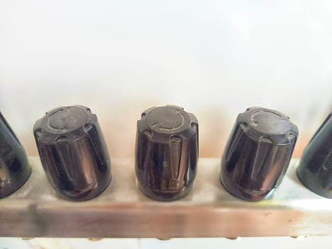 Close-up of plastic taps, valves, regulators on underfloor heating pipes and water standing in a row