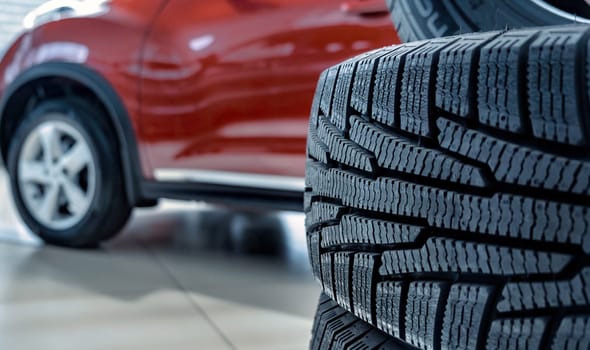 new tires that change tires in the auto repair service center, blurred background, the background is a new car in the stock blur for the industry, a four-wheeled tire set at a large warehouse. download image