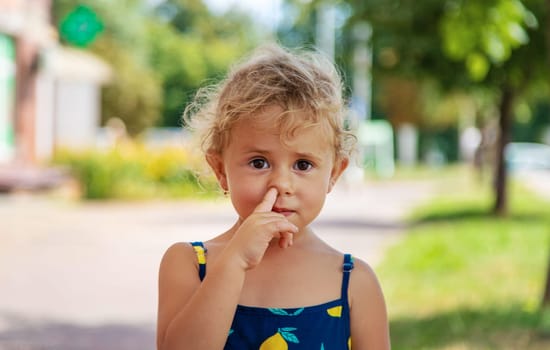 The child picks his nose. Selective focus. Kid.