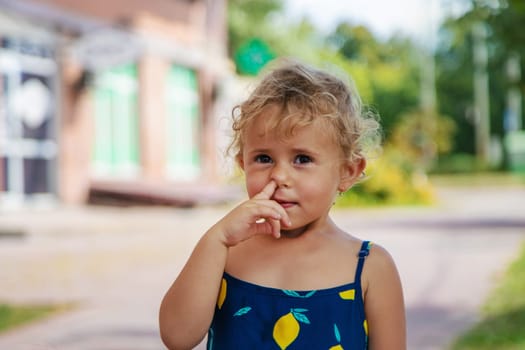 The child picks his nose. Selective focus. Kid.