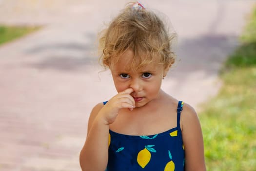 The child picks his nose. Selective focus. Kid.