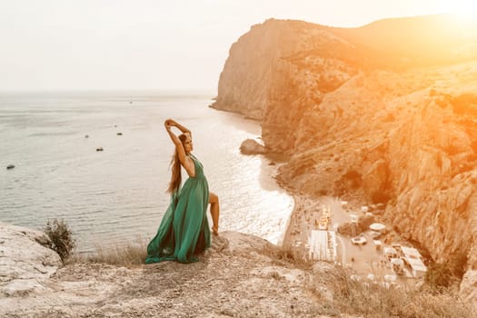 Woman sea trevel green dress. Side view a happy woman with long hair in a long mint dress posing on a beach with calm sea bokeh lights on sunny day. Girl on the nature on blue sky background