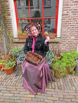 Deventer, Netherlands, December 16, 2023:Beautiful woman in the streets of Deventer in victorian style cloting during the Dickens Festival.