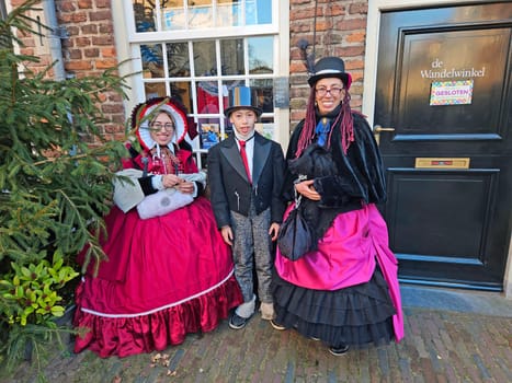 Deventer, Netherlands, December 16, 2023:Beautiful family in the streets of Deventer in victorian style cloting during the Dickens Festival.