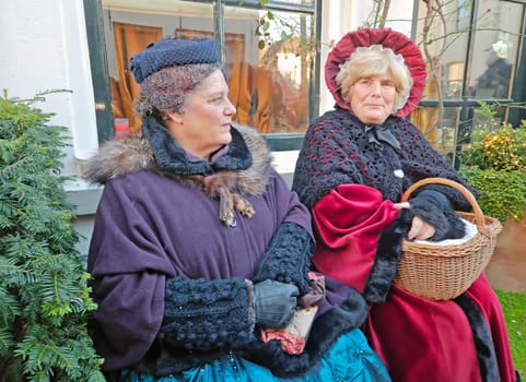 Deventer, Netherlands, December 16, 2023:Beautiful women in the streets of Deventer in victorian style cloting during the Dickens Festival.