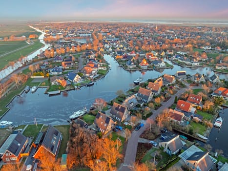Aerial view on the traditional village Koudum in Friesland the Netherlands at sunset in winter