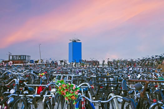 Bike storage in Amsterdam harbor in the Netherlands at sunset