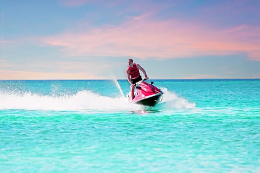 Young guy cruising on a jet ski on the caribbean sea
