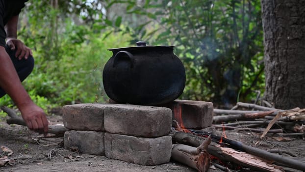 Outdoor cooking in a steel pot, camp kitchen with wood