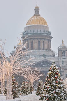 Russia, St Petersburg, St. Isaac's Cathedral and the monument to Emperor Nicholas II through lighting decorations during snowstorm, streets decorated for Christmas. High quality photo