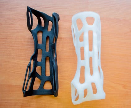 Hand arm splint corset prosthesis langet printed on a 3D printer from molten plastic. Medical orthosis, fixator, plastic overlay created on 3D printer. New modern medical 3D printing technologies