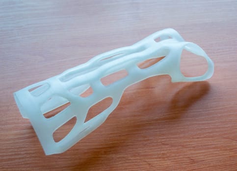 Hand arm splint corset prosthesis langet printed on a 3D printer from molten plastic. Medical orthosis, fixator, plastic overlay created on 3D printer. New modern medical 3D printing technologies