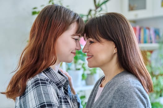 Close-up profile portrait of mother and daughter 18-20 years old. Family, communication, motherhood, friendship, relationship between parent and teenage daughter, mothers Day concept