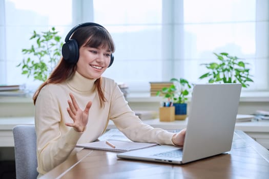 Teenage girl college student in headphones having video conference chat online meeting lesson webinar on computer laptop screen, sitting at desk at home. E-learning, education, technology, knowledge