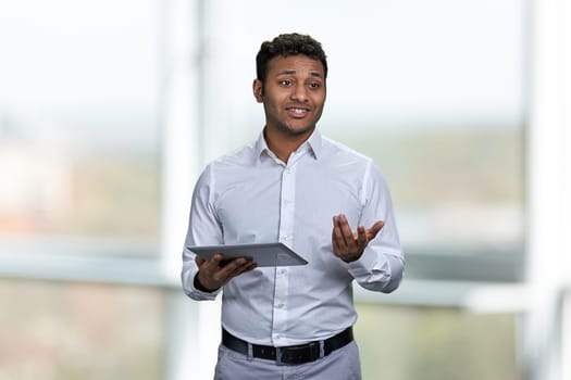 Handsome business trainer using tablet device. Blur interior background. People, business and modern technology concept.