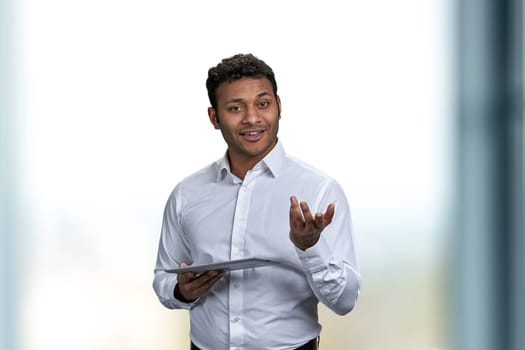 Handsome male business coach giving a lecture using digital tablet pc. Young businessman using computer tablet while giving a presentation.