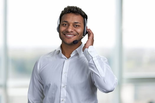 Friendly male call center operator in headset talking with customer. Young business operator man wearing customer service headset.