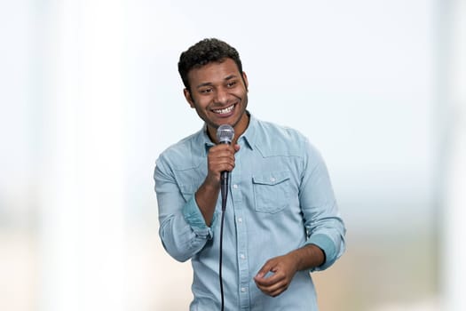 Happy cheerful man entertainer talking into microphone making speech or stand up show. People, entertainment and fun concept.