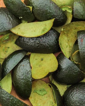 Avocado halves and their peels artfully arranged on a wood cutting board