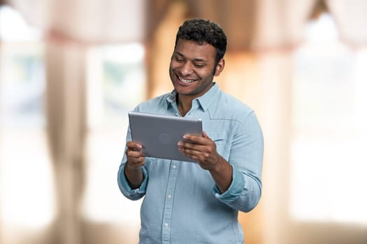 Happy young man having video chat with tablet pc. Comunication via internet.