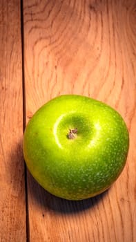 Tasty organic green juicy green apples on a rustic wooden background