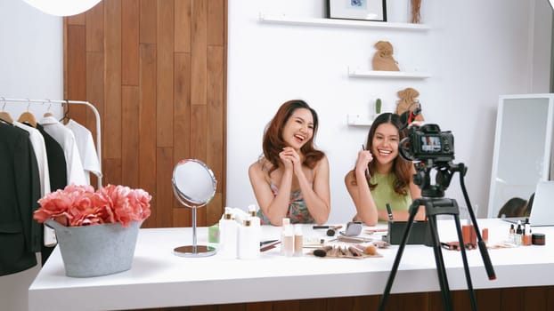 Two influencer partner shoot live streaming vlog video review makeup social media or blog. Happy young girl with vivancy cosmetics studio lighting for marketing recording session broadcasting online.