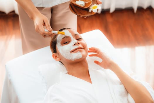 Serene ambiance of spa salon, woman customer indulges in rejuvenating with luxurious face cream massage with modern daylight. Facial skin treatment and beauty care concept. Quiescent