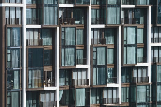 Window residential building apartment. Modern city skyscraper in day light. Apartment windows in modern skylines with day light. Many block of estate. Real estate. Closeup. Side view. Ornamented.