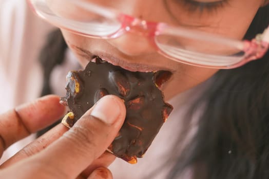 child eating dark chocolate close up .