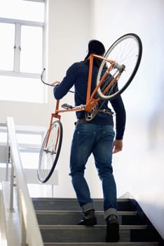 Bicycle, stairs and man with back carrying bike for healthy and eco friendly transportation for travel. Staircase, carry and cyclist with apartment building, take up and journey of walking steps.