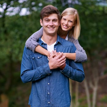Couple, portrait and happy with hug in nature or countryside for holiday, vacation or anniversary getaway. Love, man and woman with face, smile and embrace in woods or forest for relationship or care.