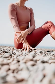 Young woman with long hair in white swimsuit and boho style braclets practicing outdoors on yoga mat by the sea on a sunset. Women's yoga fitness routine. Healthy lifestyle, harmony and meditation