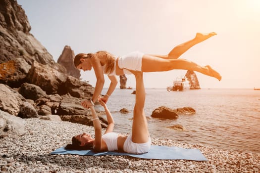 Woman sea yoga. Back view of free calm happy satisfied woman with long hair standing on top rock with yoga position against of sky by the sea. Healthy lifestyle outdoors in nature, fitness concept.