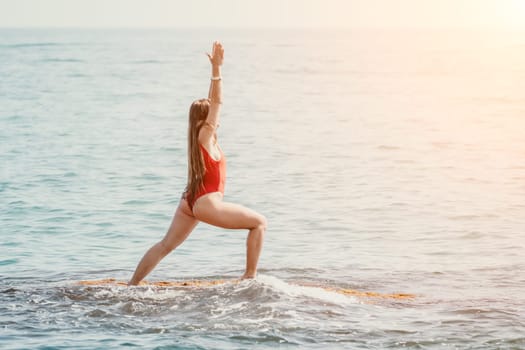 Woman sea yoga. Back view of free calm happy satisfied woman with long hair standing on top rock with yoga position against of sky by the sea. Healthy lifestyle outdoors in nature, fitness concept.