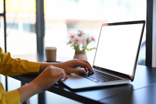 Woman hands typing on laptop keyboard, checking email or searching information.