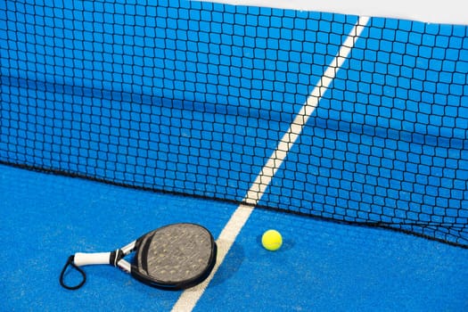 White professional paddle tennis racket with natural lighting on blue background. Horizontal sport theme poster, greeting cards, headers, website and app. High quality photo