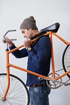 Man, studio and bike for sustainability, transportation or exercise on white background. Hipster cyclist, carbon neutral and eco friendly travel for environmental commute or fitness and trip.