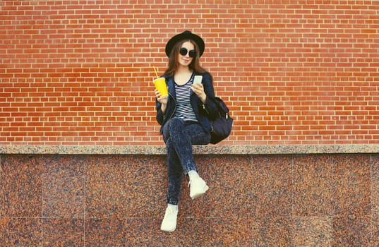 Modern caucasian young woman 20s model with mobile phone looking at device on city street