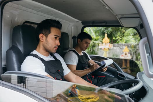 Mover workers driving truck for moving and transportation service. Teamwork in delivering furniture. Ethnicity diversity among smiling employees. House moving service concept.