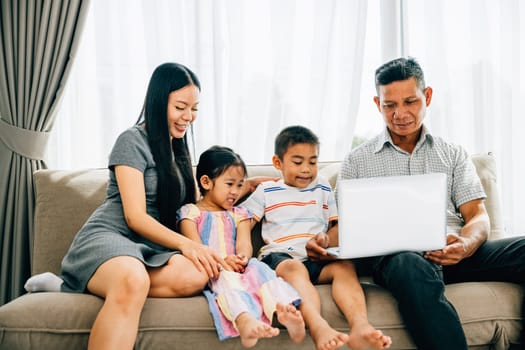 Parents and kids gathered on a sofa engrossed in a laptop smiling and exploring. The image showcases familial bonding joy and the magic of shared technology experiences.