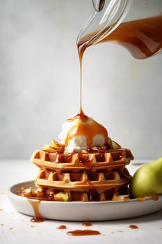 Vanilla ice cream on waffles drizzled with caramel sauce and nuts.