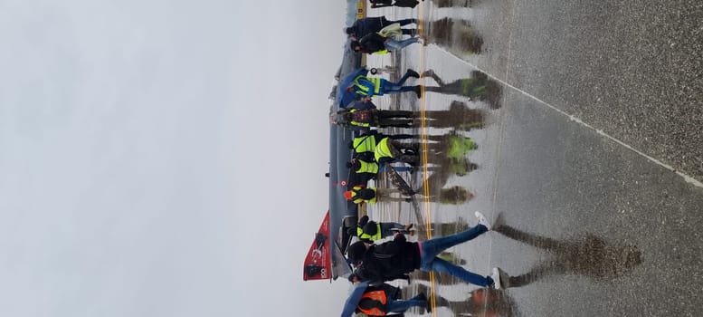 Combat fighter jet parked under the rain, surrounded by photographers, blending military prowess with artistic interest. McDonnell Douglas F-4 Phantom II of Turkish Air Force Vertical Image.