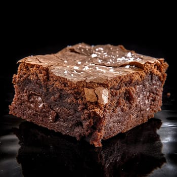 A rich, fudgy brownie with melted chocolate chips on a black background.