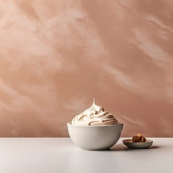 A bowl of whipped cream with a cookie beside it on a beige background.