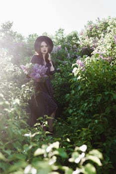 A fashionable girl with dark hair, a spring portrait in lilac tones in summer. Bright professional makeup