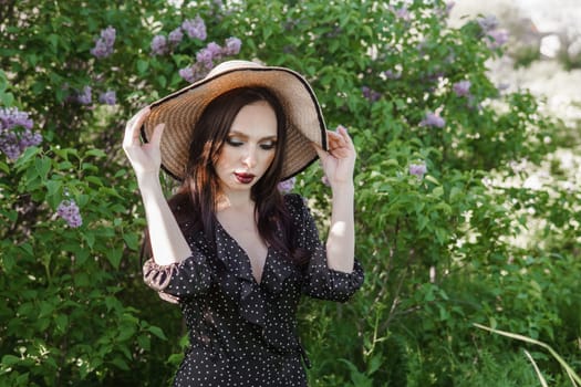 A fashionable girl with dark hair, a spring portrait in lilac tones in summer. Bright professional makeup